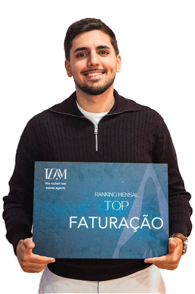 Tomás Marques, de polo preto, a sorrir enquanto segura a placa da MaisConsultores TEAM que o distingue como top de faturação no ranking mensal.